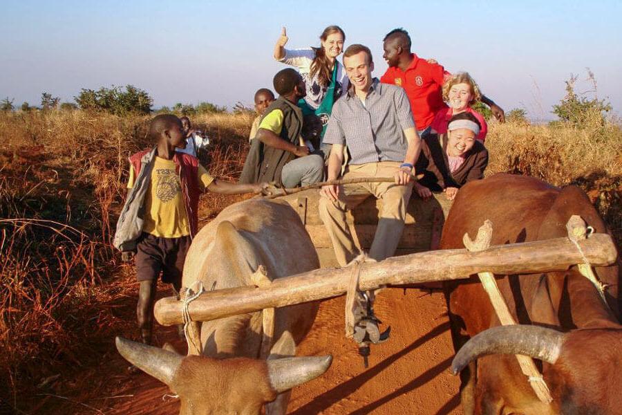 students and locals on an oxcart